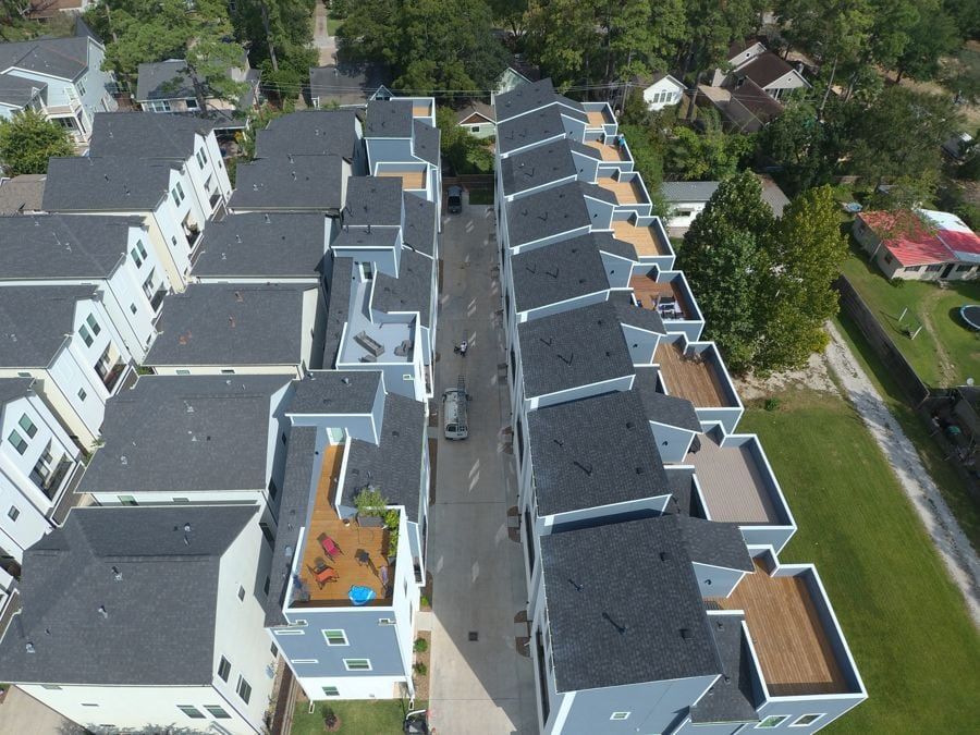Aerial view of three-story townhomes with rooftop decks