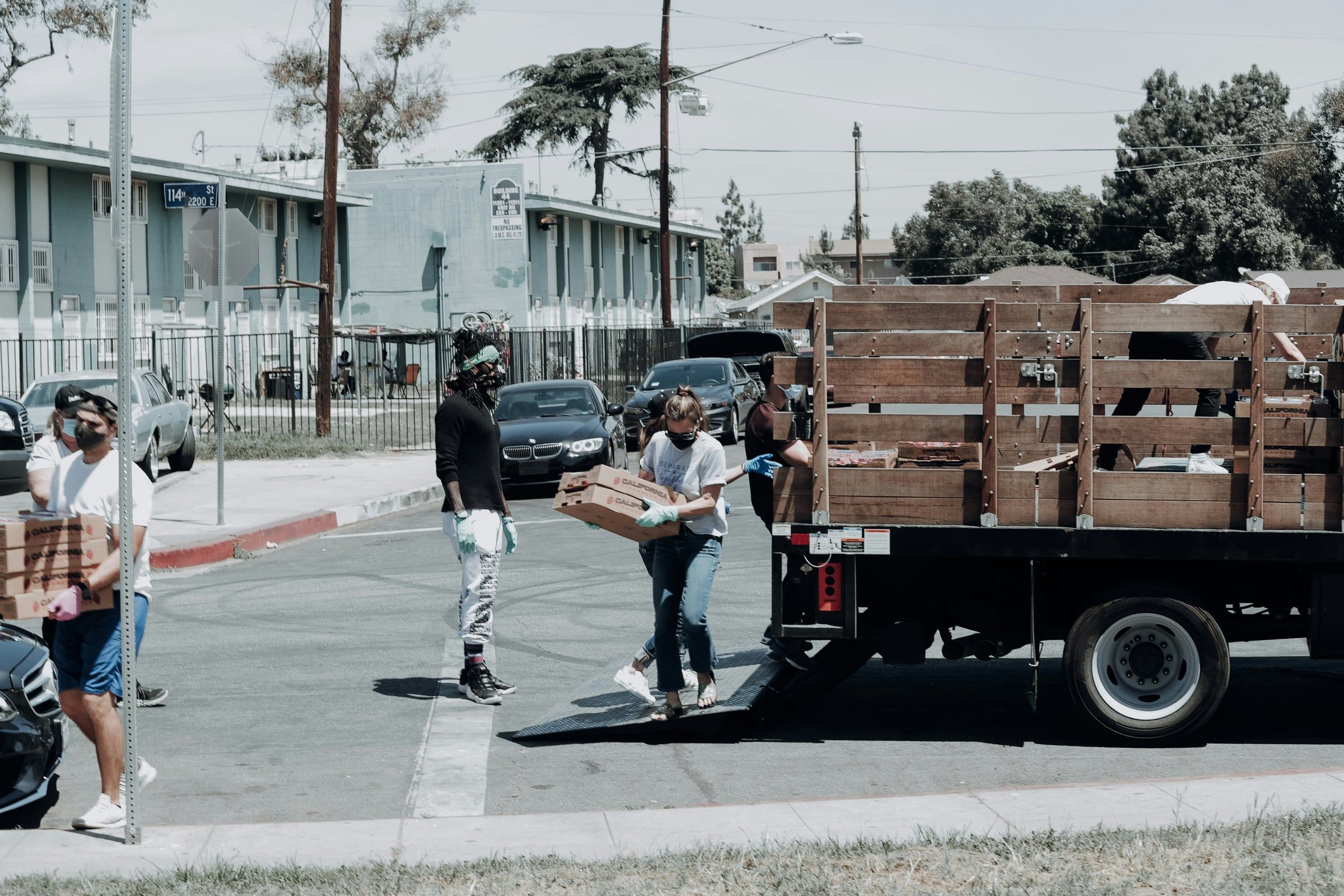 Volunteers carrying boxes of food from a truck
